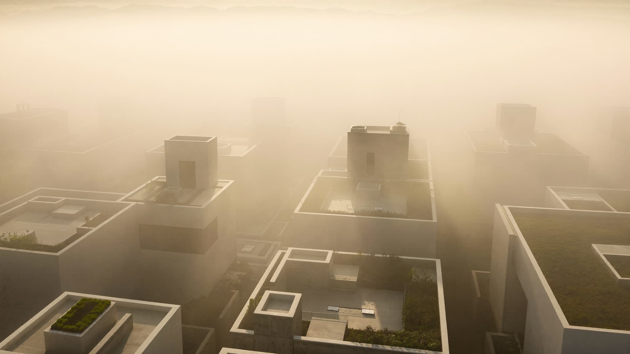 Aerial view of modern residential rooftops in warm morning haze